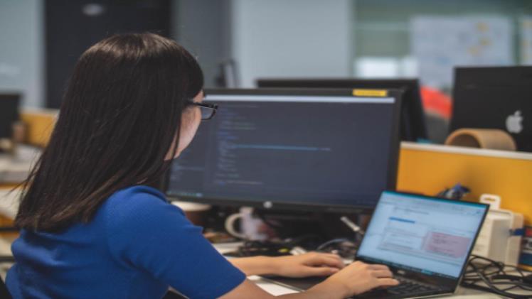An employee in an office setting using her computer to research how to use HIPAA fax and understand the basics of HIPAA compliance in faxing